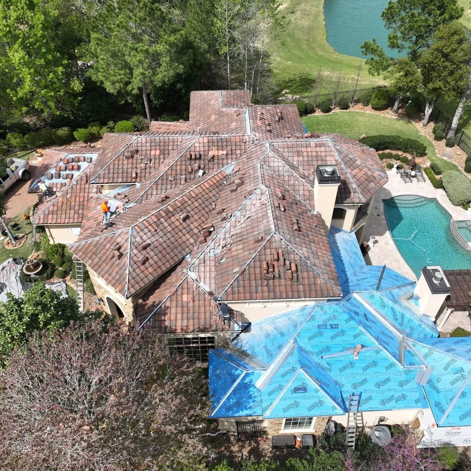 Aerial view of the same Spanish tile roof with tile going back on over new underlayment